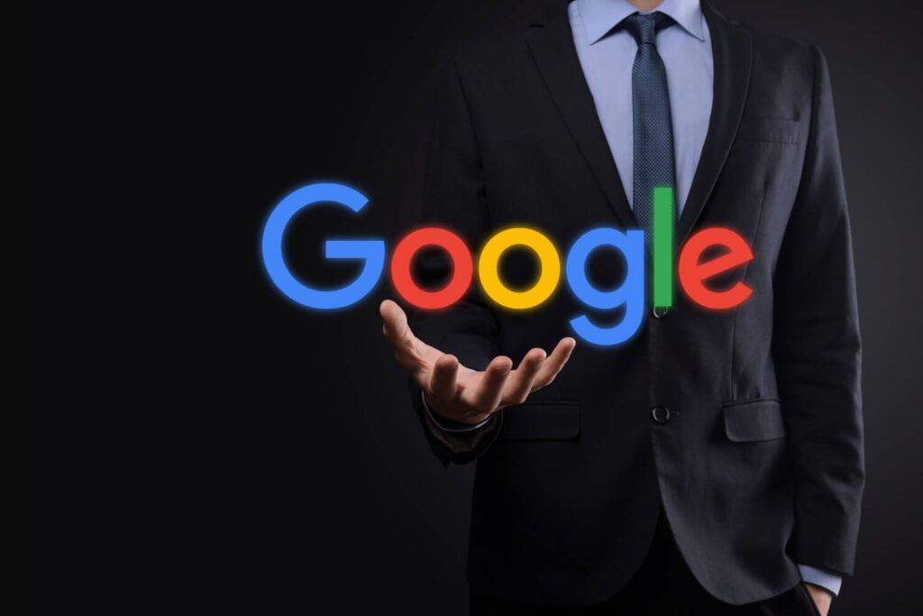 man in suit holding the google logo